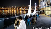 People enjoy drinks amid concerns about the spread of the coronavirus disease (COVID-19), at Han River park in Seoul, South Korea, April 29, 2020. REUTERS/Kim Hong-Ji