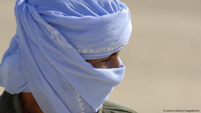 Portrait of a man with a light blue scarf around his head and mouth (picture-alliance / imageBroker)