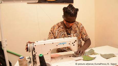 David Ochieng von Lookslike Avido näht mit Mundschutz an einer Maschine sitzend (picture-alliance/ZumaPress/D. Sigwe)