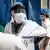 A doctor wears wears a protective mask and a protective visor inside a hospital