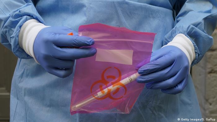 Doctor transporta en una bolsa de plástico un test de coronavirus.