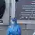 Медицинско лице в предпазен костюм пред Института "Пирогов" в София