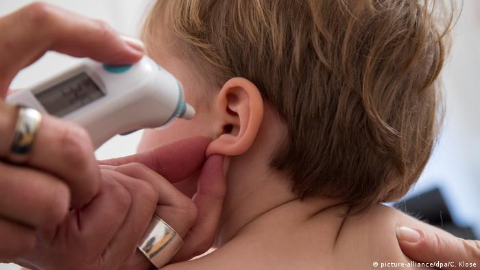 Child having temperature being taken in ear