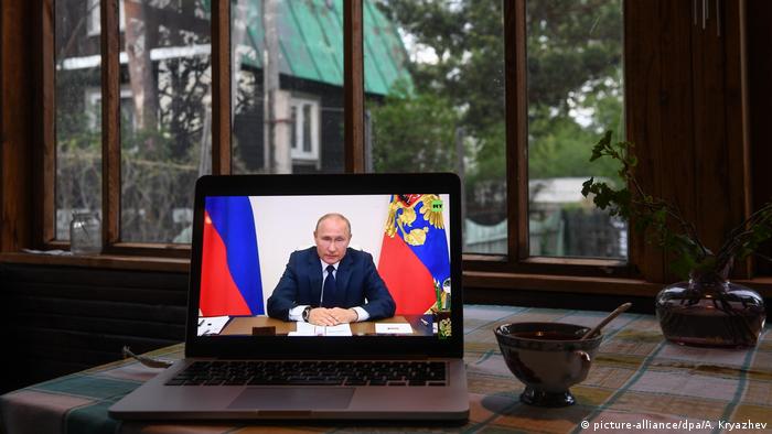 There is a computer on the table on which they are watching Putin's speech