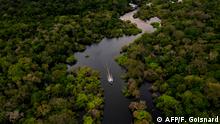Aerial view showing a boat speeding on the Jurura river in the municipality of Carauari, in the heart of the Brazilian Amazon Forest, on March 15, 2020. - Many young people in the heart of the Amazon rainforest choose their community over the city. (Photo by Florence GOISNARD / AFP)