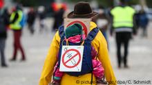 02.05.2020, Baden-Württemberg, Stuttgart: Eine Teilnehmerin einer Protestkundgebung der Initiative «Querdenken» trägt auf dem Cannstatter Wasen ein Schild gegen Impfungen auf ihrem Rücken. Nach Ansicht des Experten Bernd Harder von der Gesellschaft zur wissenschaftlichen Untersuchung von Parawissenschaften könnte die Corona-Krise Impfskeptiker aber mittelfristig dazu bewegen, künftig mehr auf Schutzimpfungen zu vertrauen. Foto: Christoph Schmidt/dpa +++ dpa-Bildfunk +++ | Verwendung weltweit