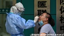 A medical worker takes a swab sample from a man to be tested for the COVID-19 novel coronavirus in Wuhan, in Chinas central Hubei province on May 13, 2020. - Wuhan plans to conduct coronavirus tests on the Chinese city's entire population after new cases emerged for the first time in weeks in the cradle of the global pandemic, state media reported on May 12. (Photo by Hector RETAMAL / AFP) (Photo by HECTOR RETAMAL/AFP via Getty Images)