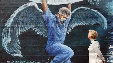 A male nurse is depicted on the side of a building wearing angel-like wings.