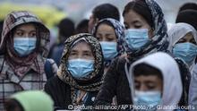 4.5.2020, Piraeus, Griechenland, Refugees and migrants wearing masks to prevent the spread of the new coronavirus, wait to get on a bus after their arrival at the port of Piraeus, near Athens, Monday, May 4, 2020. Greek authorities are moving 400 migrants, mostly families, to the mainland to help ease overcrowded conditions at the camp Moria in Lesbos island. (AP Photo/Petros Giannakouris) |