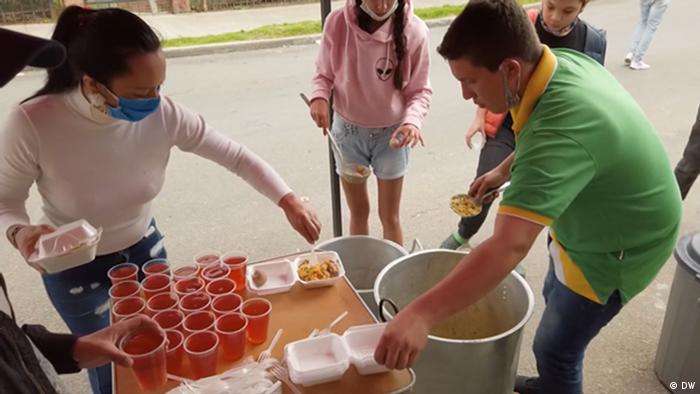 Volunteers dish out food for hungry people