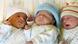 Three babies lying in a cot Three babies lying in a cot
