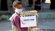 A child wearing a protective mask receives humanitarian aid in Yemen's third city of Taez, on May 8, 2020, amid the novel coronavirus pandemic crisis. - Yemen has suffered years of war that have driven millions from their homes and plunged the country into what the United Nations describes as the world's worst humanitarian crisis. (Photo by AHMAD AL-BASHA / AFP) (Photo by AHMAD AL-BASHA/AFP via Getty Images)