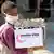 Seorang anak di Yaman memakai masker sambil mengangkut bantuan makanan.