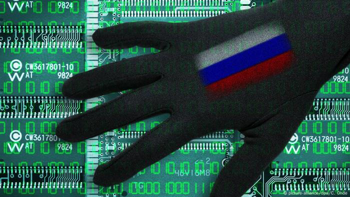 Schwarze Hand mit Russland-Fahne über Computerplatinen, Symbolfoto Cyberattacken