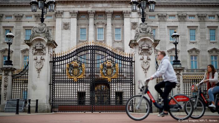 people bike past Buckingham Palace