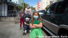 26.04.2020 *** A mother and their children pose sporting their face masks in a street of Santa Cruz de tenerife on April 26, 2020 during a national lockdown to prevent the spread of the COVID-19 disease. - After six weeks stuck at home, Spain's children were being allowed out today to run, play or go for a walk as the government eased one of the world's toughest coronavirus lockdowns. Spain is one of the hardest hit countries, with a death toll running a more than 23,000 to put it behind only the United States and Italy despite stringent restrictions imposed from March 14, including keeping all children indoors. Today, with their scooters, tricycles or in prams, the children accompanied by their parents came out onto largely deserted streets. (Photo by DESIREE MARTIN / AFP) (Photo by DESIREE MARTIN/AFP via Getty Images)