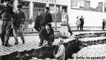 picture taken in April 1960 in Valdivia of people looking at an enormous crack on a street due to the earthquake that struck the area on May 22, 1960. AFP PHOTO (Photo credit should read STF/AFP via Getty Images)