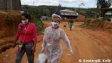 Vanderlecia Ortega dos Santos, 32, a nurse from the Witoto tribe, an indigenous ethnic group, who has volunteered to provide the only frontline care protecting her indigenous community of 700 families from the COVID-19 outbreak, and language teacher and artisan Natalina Martins Ricardo, 42, from the Bare Tribe, wear protective masks that read Indigenous lives matter, as walk along a road in Parque das Trios, during the coronavirus disease (COVID-19) outbreak, in the Taruma district, Manaus, Brazil, April 26, 2020. Because we were so devoid of public assistance, I took the initiative to start a campaign on social media to receive donations of food and hygiene kits, said Santos. REUTERS/Bruno Kelly SEARCH CORONAVIRUS INDIGENOUS NURSE FOR THIS STORY. SEARCH WIDER IMAGE FOR ALL STORIES. TPX IMAGES OF THE DAY