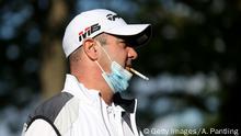 LONDON, ENGLAND - MAY 13: A man smokes a cigarette whilst wearing a face mask before his round of golf at West Essex Golf Course on May 13, 2020 in London, England. The prime minister announced the general contours of a phased exit from the current lockdown, adopted nearly two months ago in an effort curb the spread of Covid-19. (Photo by Alex Pantling/Getty Images)