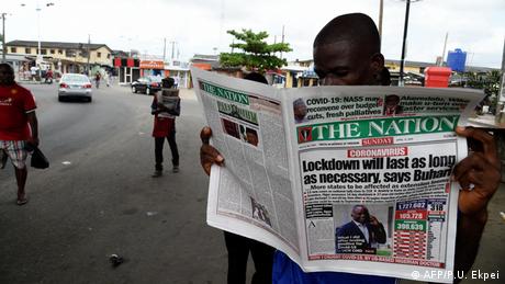 A man reads a newspaper at a newsstand in Lagos to know more about the extended lockdown as part of measures to prevent the spread of COVID-19 coronavirus. Across the globe, media outlets face economic challenges in the wake of the crisis.