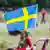 A Sweden flag tied to a fence in a park