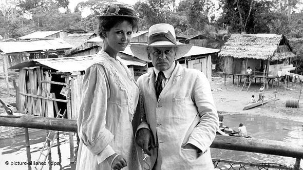 A scene from Fitzcarraldo featuring Cardinale in an old fashioned dress next to actor Klaus Kinski.