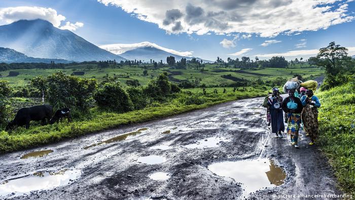 Women walk along a muddy road in Virunga National Park