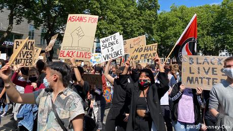 Teilnehmer einer Anti-Rassismus-Demonstration halten Schilder mit der Aufschrift „Black lives matter“ und „No hate, no fear“ hoch