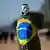 Homem enrolado em bandeira nacional e com máscara em protesto contra o governo Bolsonaro em Brasília