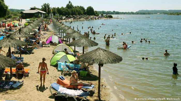 People sunbathing on the beach at the lake in Xanten, Germany
