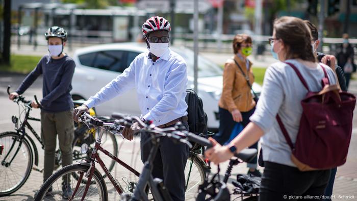 Karamba Diaby greets supporters on a bicycles