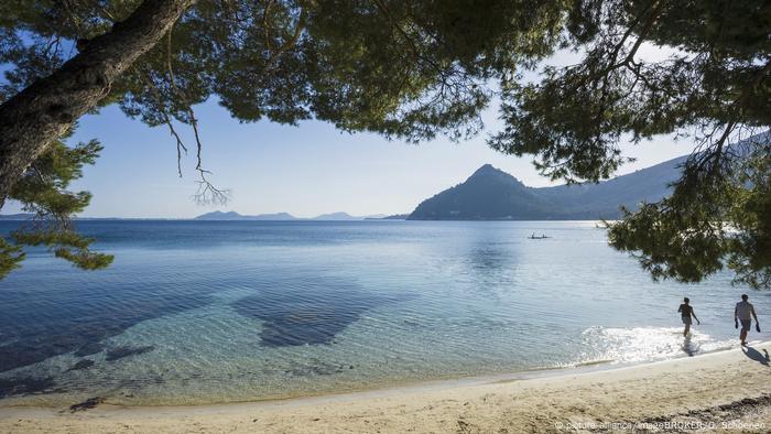 Zwie einsame Spaziergänger am Strand, Cala Formentor, Mallorca, Spanien (picture-alliance/imageBROKER/D. Schoenen)