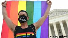 A man waves a rainbow flag in front of the US Supreme Court that released a decision that says federal law protects LGBTQ workers from discrimination on June 15, 2020 in Washington,DC. - The US top court has ruled it illegal to fire workers based on sexual orientation. (Photo by JIM WATSON / AFP)