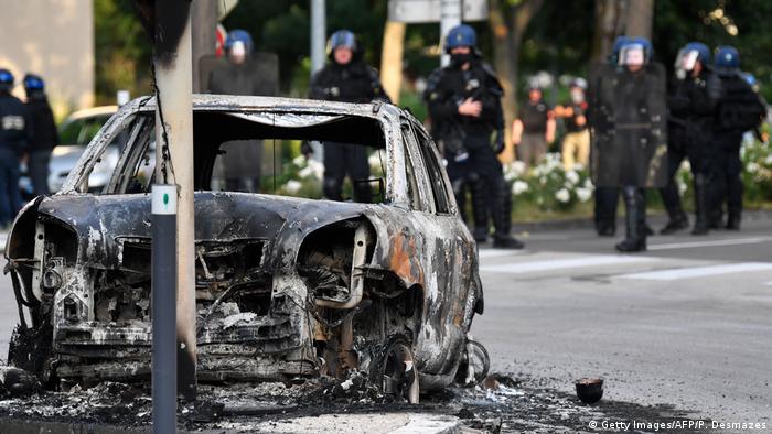 Сожженный в результате беспорядков автомобиль на улице в пригороде Дижона