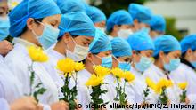 04.04.2020, China, Ganzhou: Nurses and doctors at Huichang People's Hospital pay tribute as China holds national mourning for those who died of the coronavirus in Ganzhou city, east China's Jiangxi province, 4 April 2020. Foto: Zhua Haipeng/HPIC/dpa |