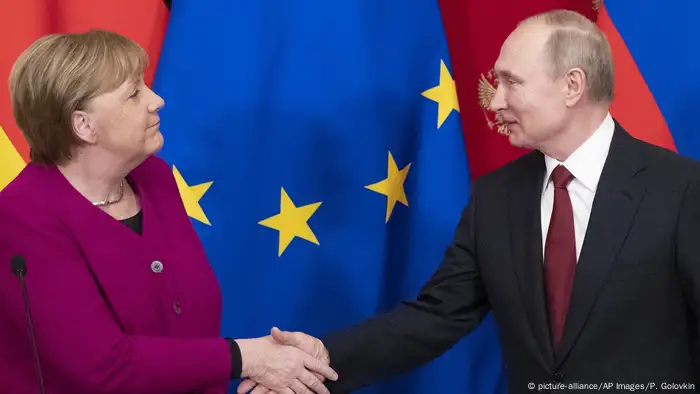 Merkel und Putin shaking hands