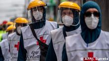 Members of the Red Cross are seen at the Ciudad Bolivar neighborhood, one of the areas with more COVID-19 cases in Bogota, on June 17 , 2020. - Bogota is on alert for the high occupation of intensive care units amid the new coronavirus pandemic. (Photo by Juan BARRETO / AFP)