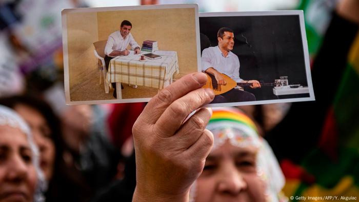 Eine Frau hält die Fotos von dem kurdischen Politiker Selahattin Demirtas in der Hand