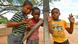 Three Nambian children pose by a fence post Three Nambian children pose by a fence post