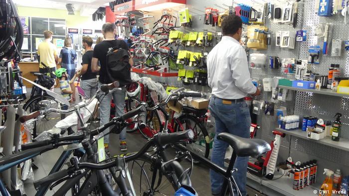 A group of shoppers in a bike store waiting to check out