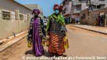 28.04.2020, Senegal, Pikine: Frauen mit Mundschutz tragen Lebensmittel-Spenden nach Hause. In den Stadtteilen «Guinaw Rail South» und «Yenne» der Stadt Pikine werden Nahrungsmittel wie Reis und Öl für ca. 1 Million Haushalte, die unter den Einschränkungen durch die Coronavirus-Pandemie leiden, bereitgestellt. Foto: Sadak Souici/Le Pictorium Agency via ZUMA/dpa +++ dpa-Bildfunk +++ |