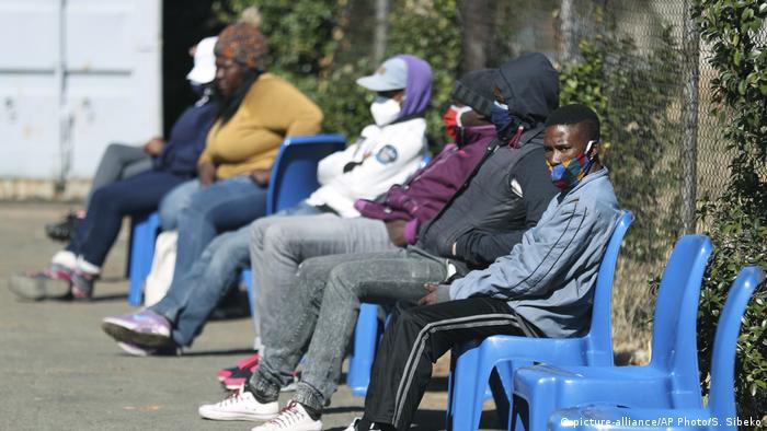 Volunteers to test a COVID-19 vaccine wait outside a hospital in Soweto, Johannesburg.