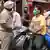 Indian police conduct a lockdown travel check on two moped riders 