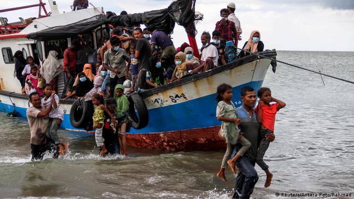 Rohingya refugees disembarking from a boat landing in Indonesia