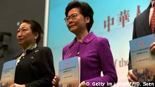Hong Kong's Chief Executive Carrie Lam (C) poses with Justice Secretary Teresa Cheng (L) while holding copies of the new national security law during a press conference at the government headquarters in Hong Kong on July 1, 2020, on the 23rd anniversary of the city's handover from Britain to China. - Hong Kong police made their first arrest on July 1 under Beijing's new national security law as the city greeted the anniversary of its handover to China with protests banned and its cherished freedoms looking increasingly fragile. (Photo by Daniel SUEN / AFP) (Photo by DANIEL SUEN/AFP via Getty Images)