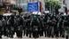 Riot police in Hong Kong walk as anti-government protesters march during a demonstration on July 1, 2019 Riot police in Hong Kong walk as anti-government protesters march during a demonstration on July 1, 2019