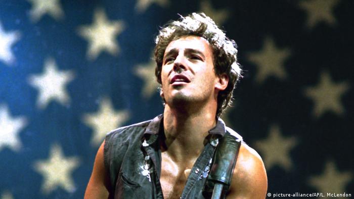 Bruce Springsteen, im Hintergrund sind die Sterne der US-amerikanischen Flagge zu sehen.