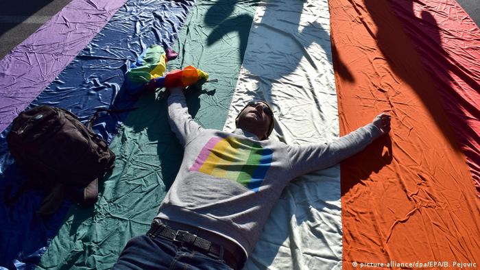 A man rests on a pride flag at Montenegro's Gay Pride parade in Podgorica