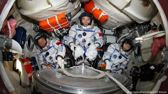 تظهر الصورة ثلاثة رواد فضاء صينيين في تدريب على كبسولة تحاكي عودة سفينة شنتشو 9 الفضائية إلى الأرض.