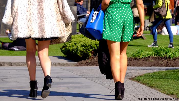 Women in skirts walk in the streets.
